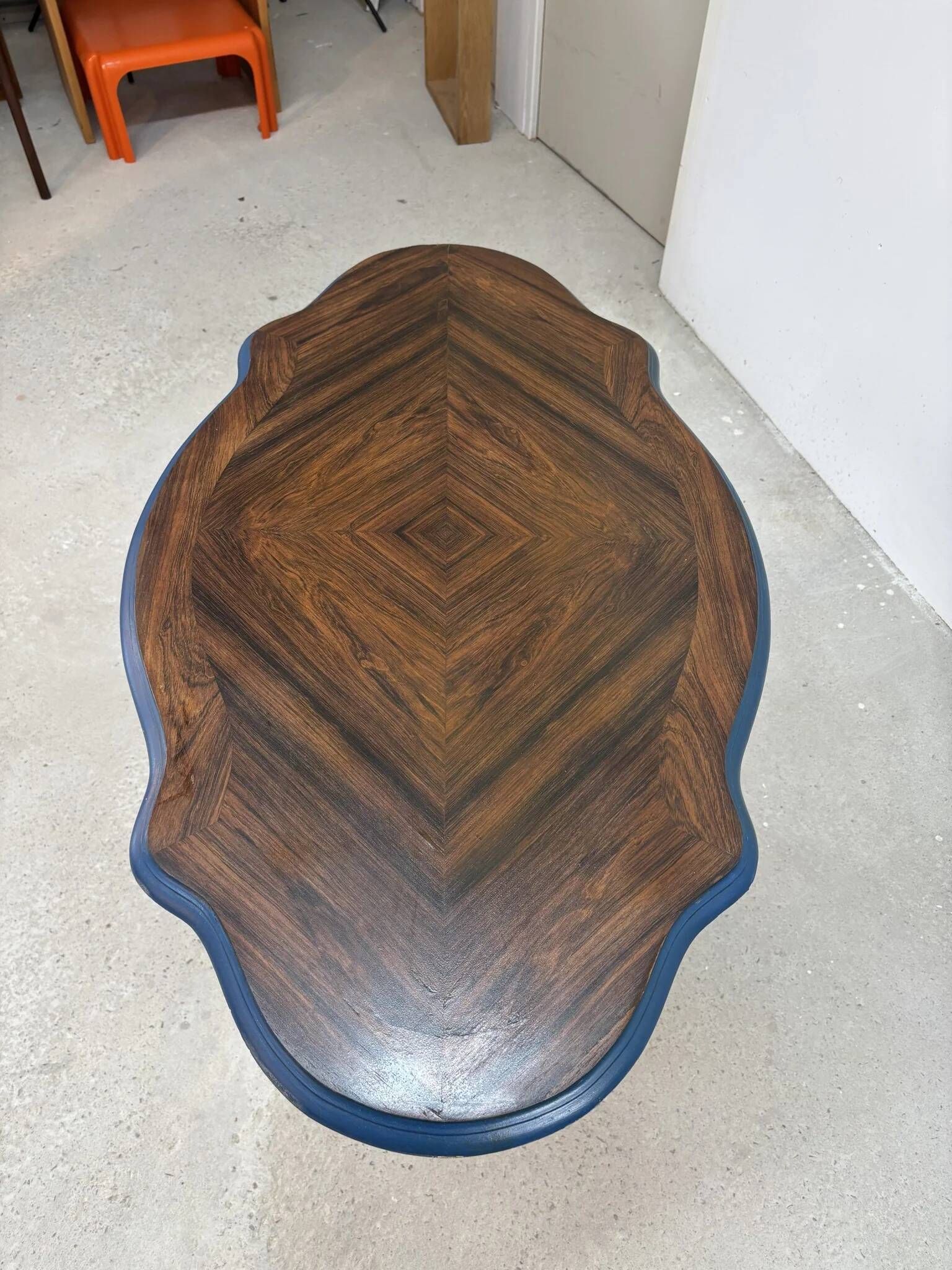 Wooden gueridon with a violin-shaped top in Rio rosewood, central base resting on four legs, reinterpreted in Baltic blue.
