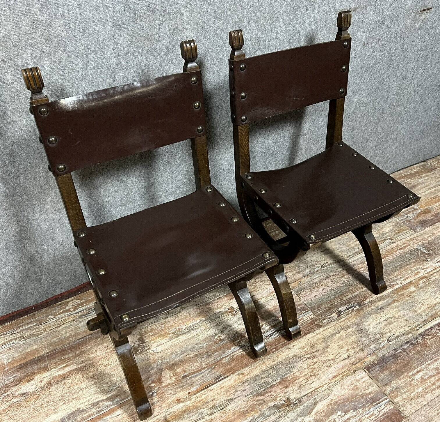 Pair of medieval style chairs in solid wood and leather, 19th century, circa 1850