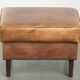 Cowhide ottoman with a beautiful patina finished with decorative nails