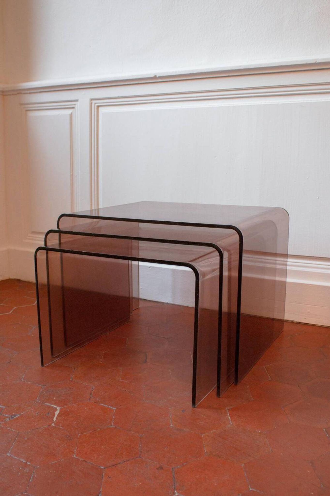 Vintage trio of nesting tables in smoked plexiglass by Michel Dumas, year.