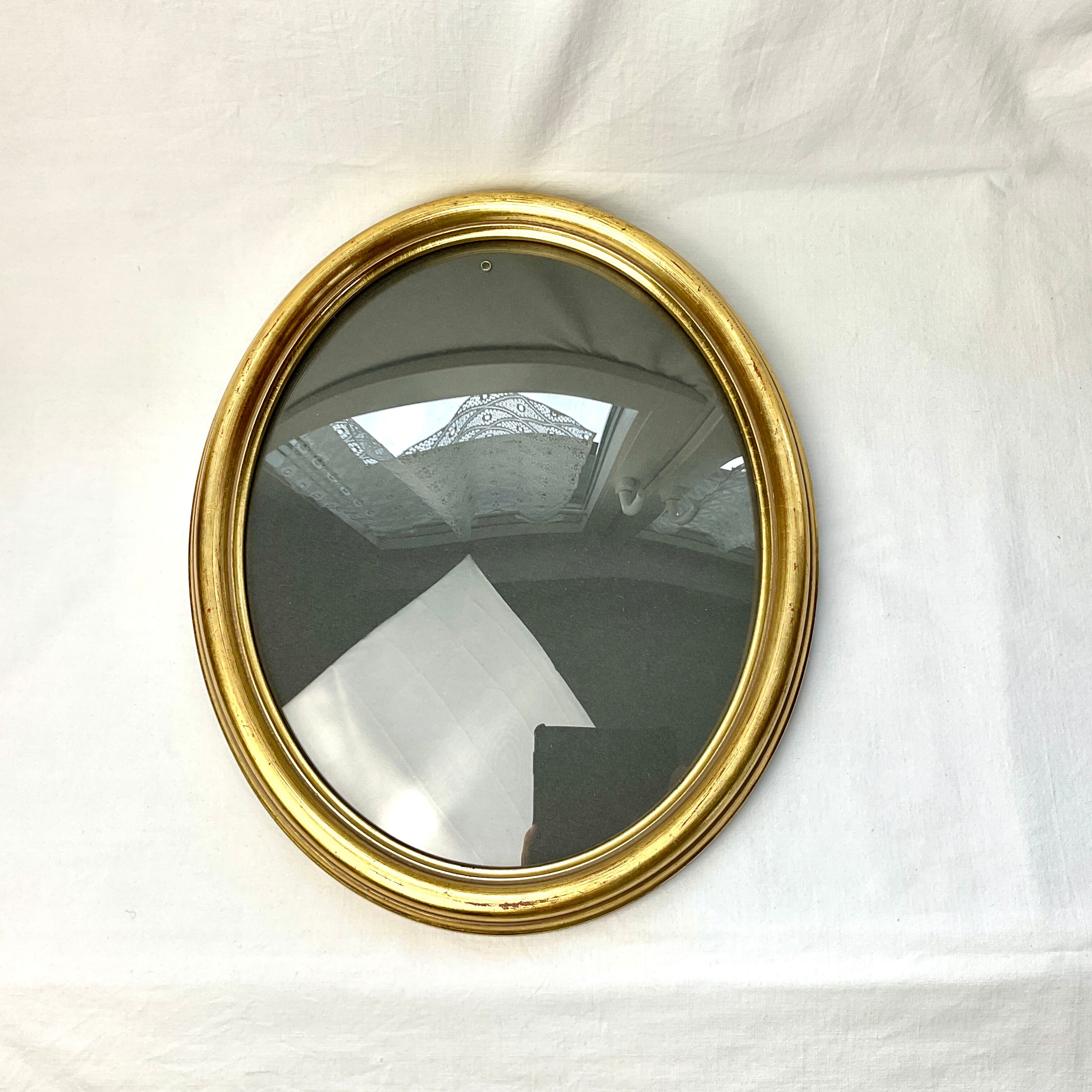 Old oval gilded wooden frame with domed glass