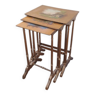 Sets of three nesting tables with painted landscape decorations in poplar.