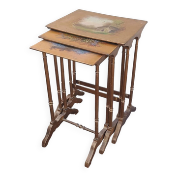 Sets of three nesting tables with painted landscape decorations in poplar.