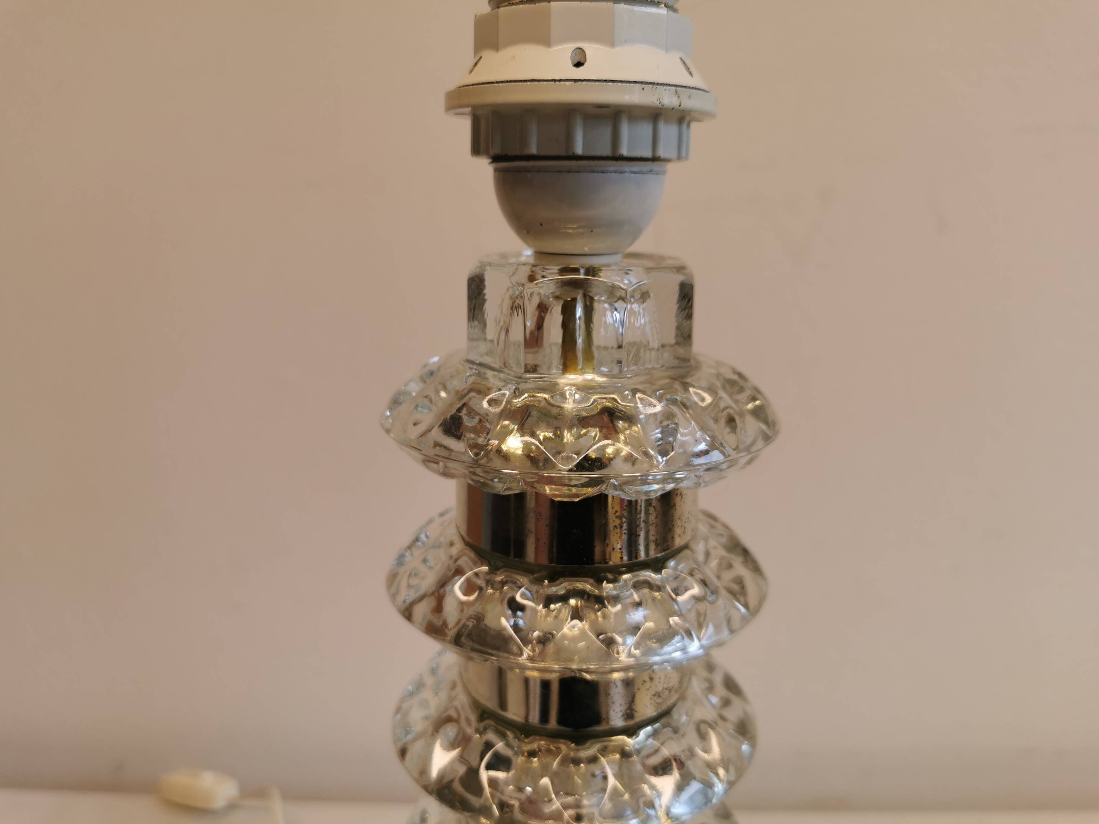 Table lamp made of transparent crystal glass and silver colored spacers.