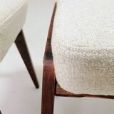 Pair of wooden stools with beige fabric.