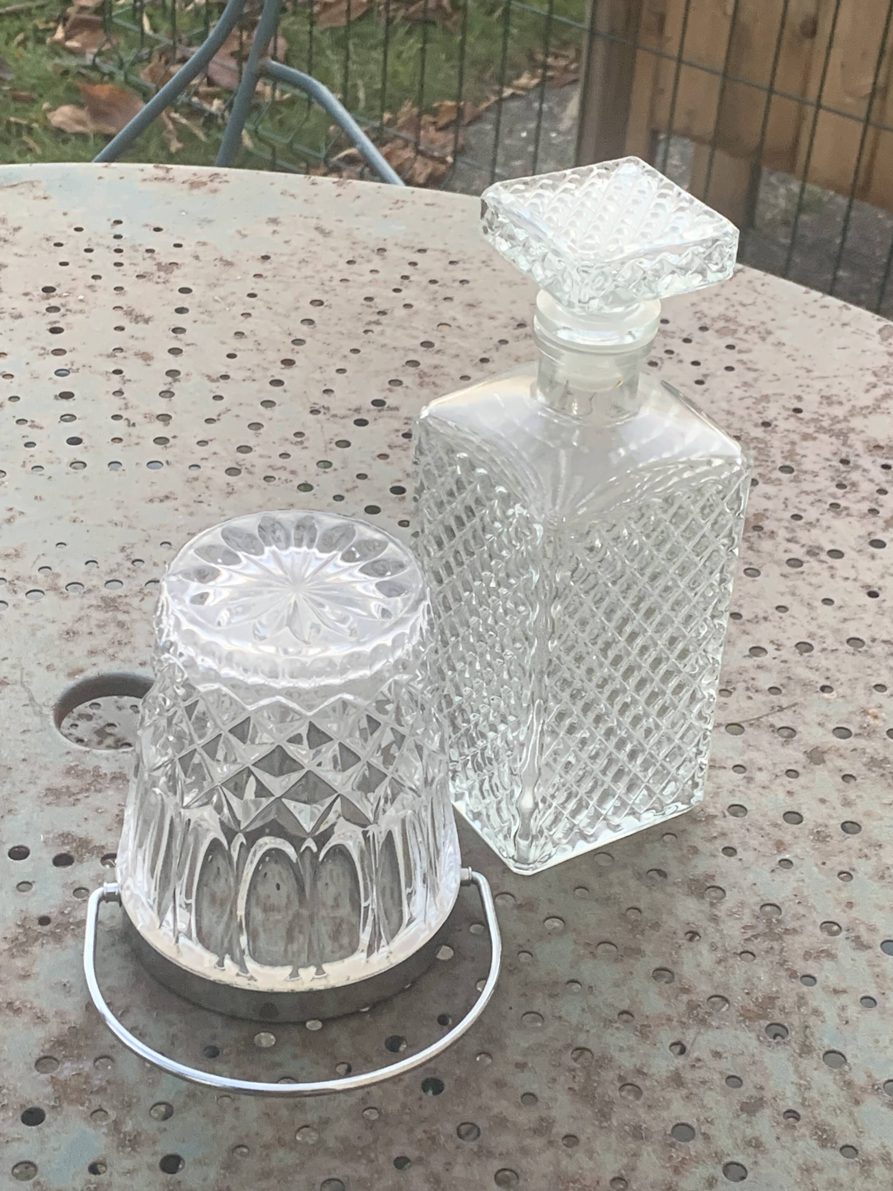 Whiskey carafe and ice bucket in transparent glass and silver-colored metal handle