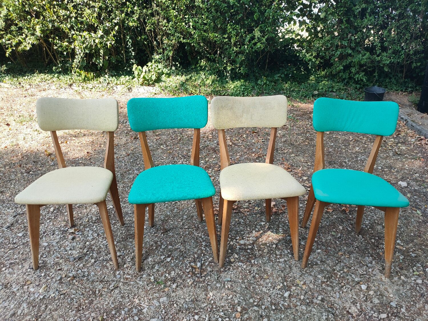 Set of 4 vintage chairs in wood and imitation blue leather dating from the 50s. Wooden structure. Seat and backrest in imitation leather 2 mint green and 2 yellow. Seating dimension: 46 cm. Good state of conservation, some traces of wear.