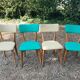 Set of 4 vintage chairs in wood and imitation blue leather dating from the 50s. Wooden structure. Seat and backrest in imitation leather 2 mint green and 2 yellow. Seating dimension: 46 cm. Good state of conservation, some traces of wear.