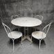 Antique painted wrought iron garden furniture, round table and four chairs.