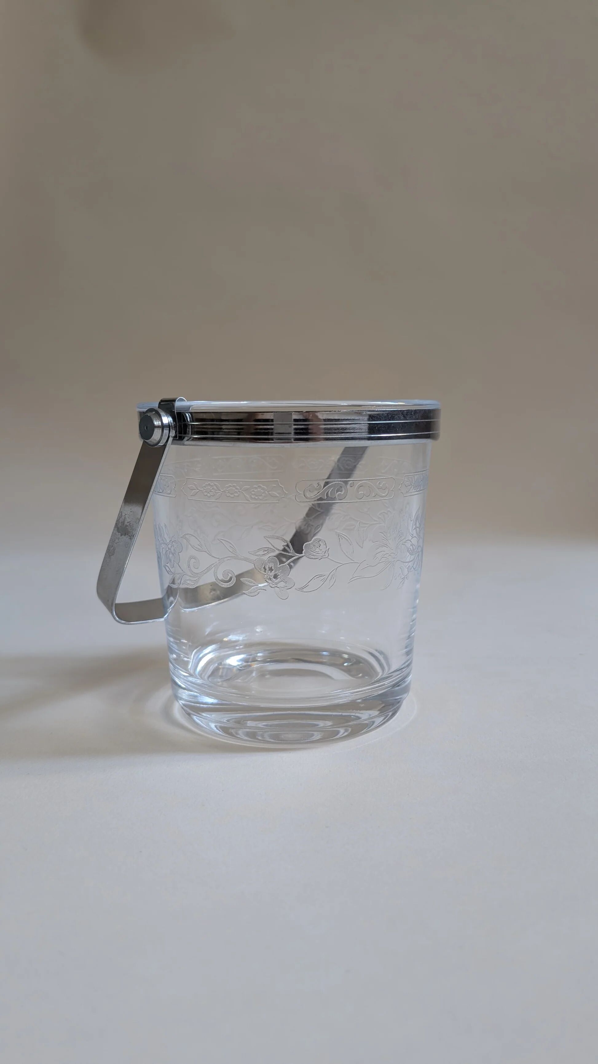 Clear glass ice bucket with an etched floral design