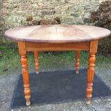 Table ovale ancienne en cerisier à piétement parapluie.