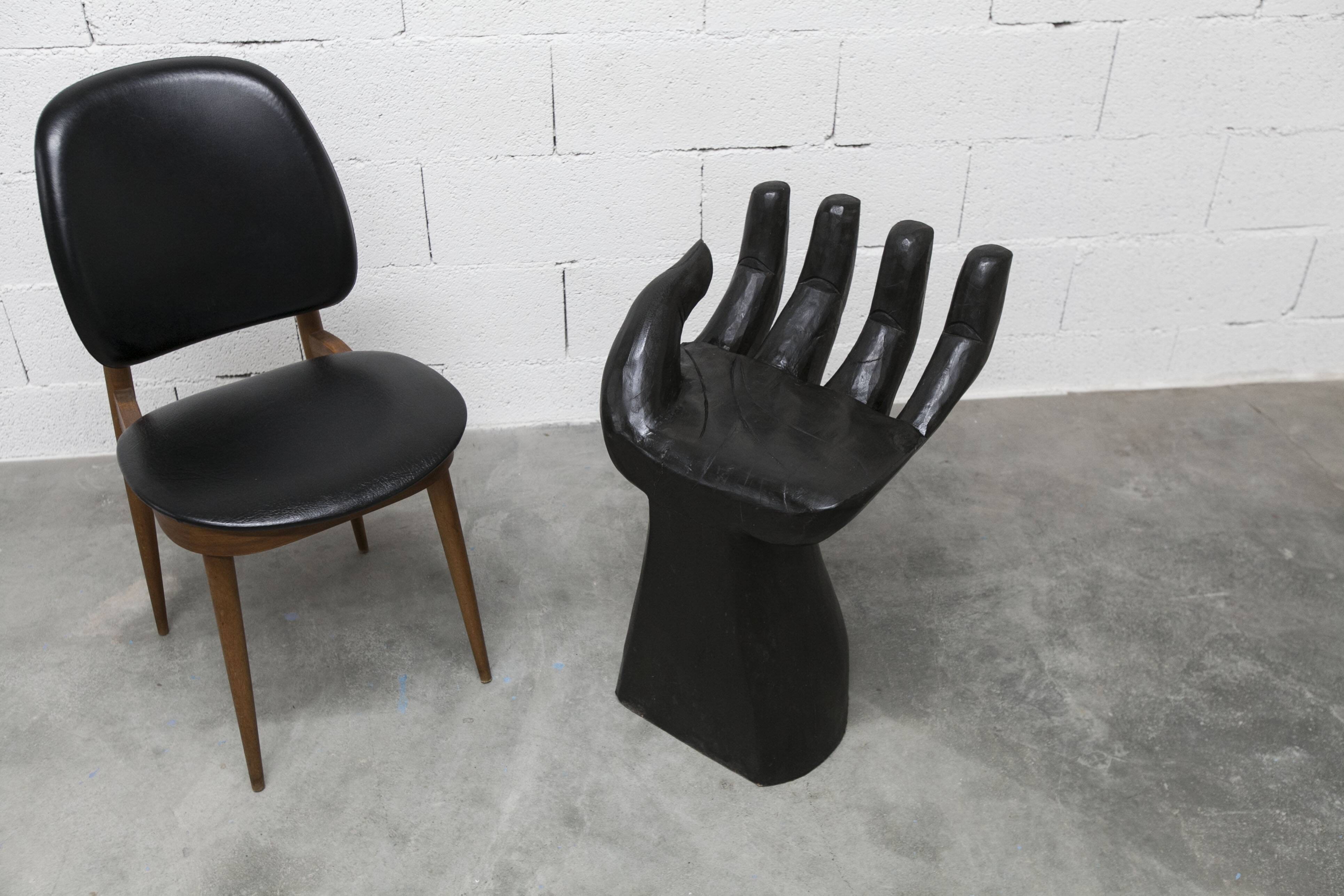 Black armchair chair in carved wood in the shape of a hand
