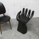 Black armchair chair in carved wood in the shape of a hand