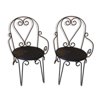 Pair of old garden chairs in wrought iron with volutes