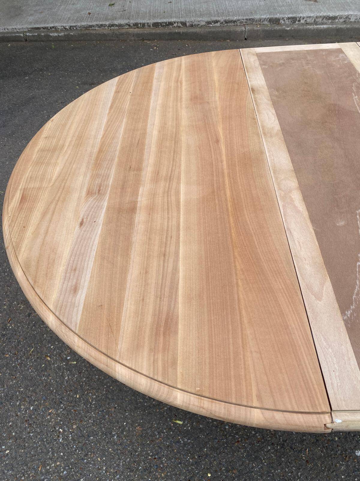 Round dining table with a central pedestal, extendable, stripped in solid walnut with 2 extensions.