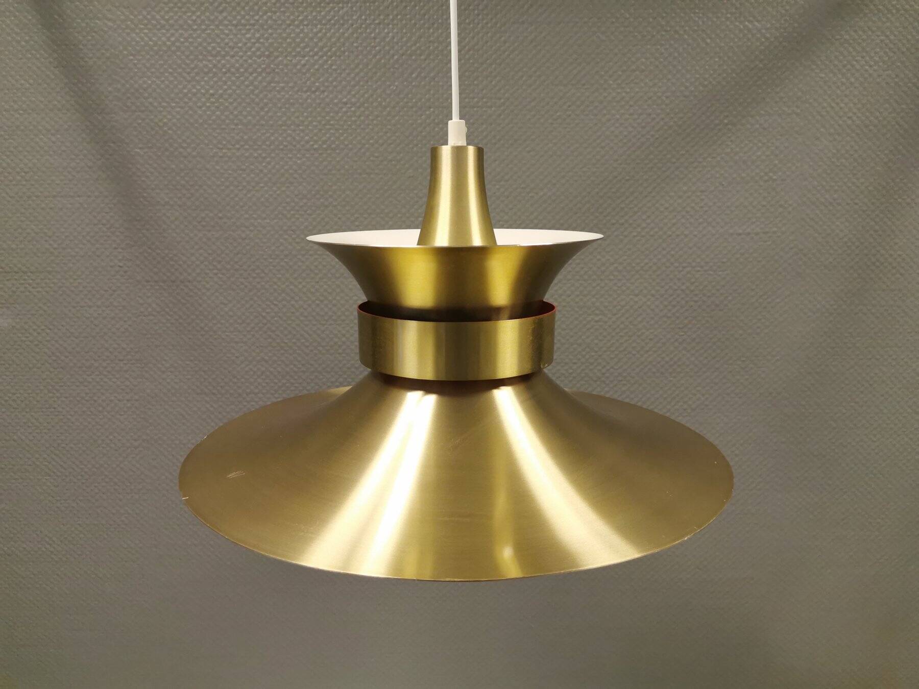 Large hanging lamp, made of brass-coloured aluminium with red and white contrast lacquer inside.