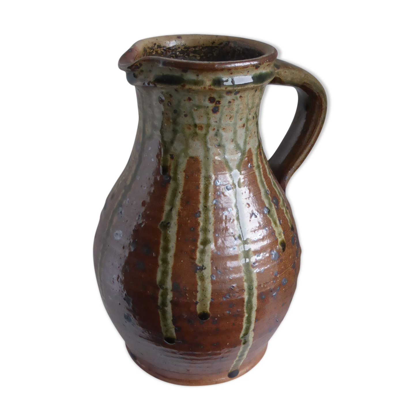 Old pitcher in brown sandstone with green drippings