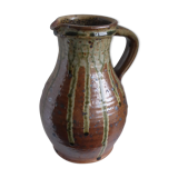 Old pitcher in brown sandstone with green drippings