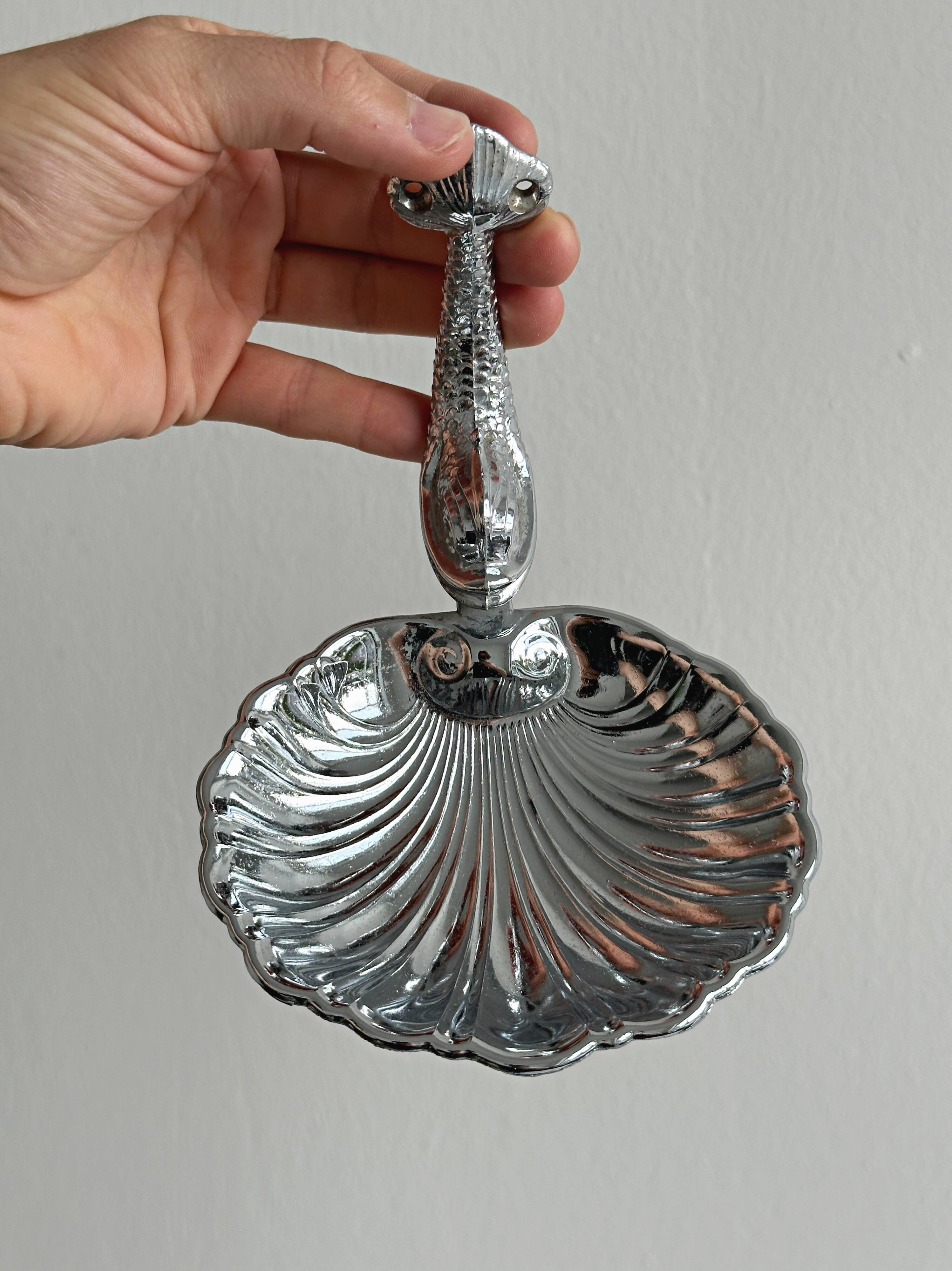 Soap dish, shell-shaped lightweight metal catchall.