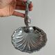 Soap dish, shell-shaped lightweight metal catchall.