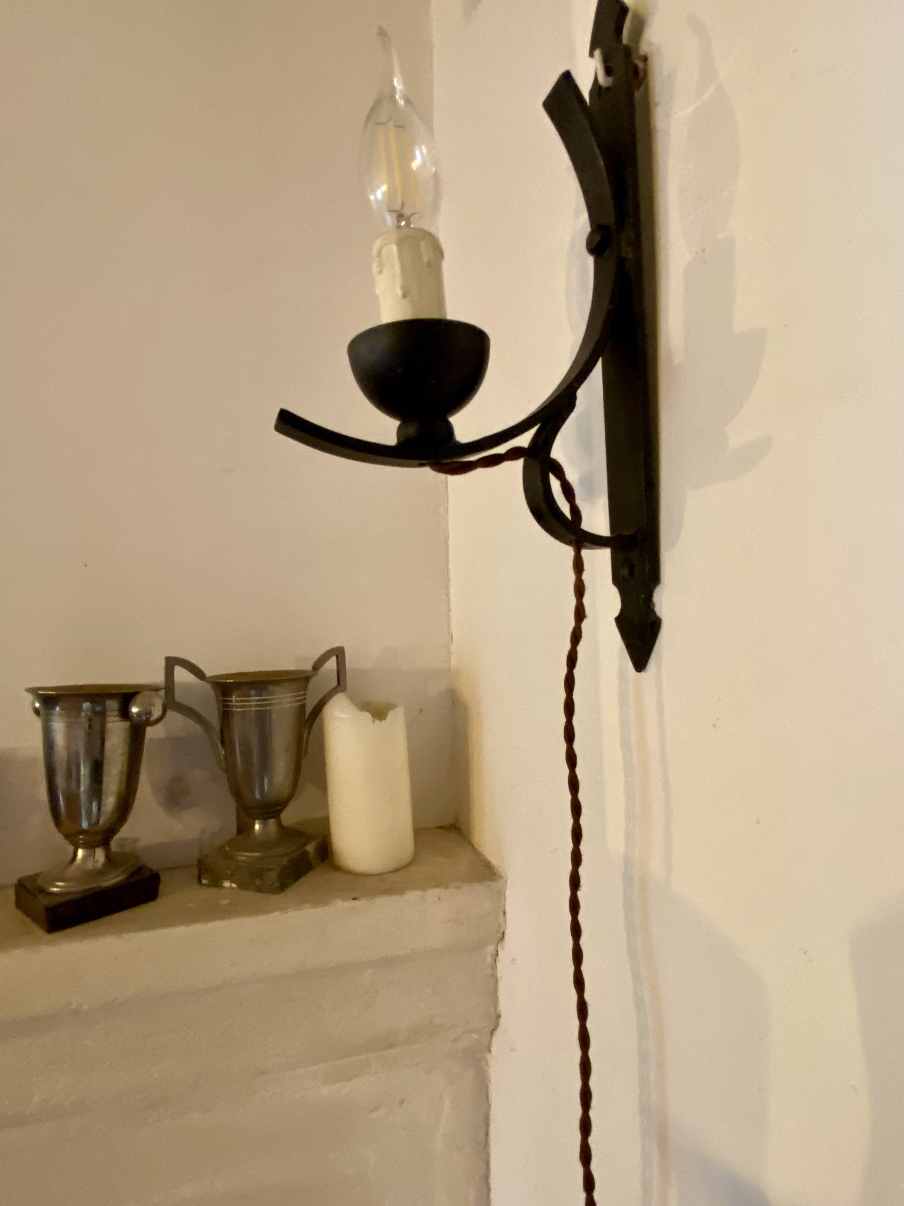 Two wrought iron wall lights, fabric cable.