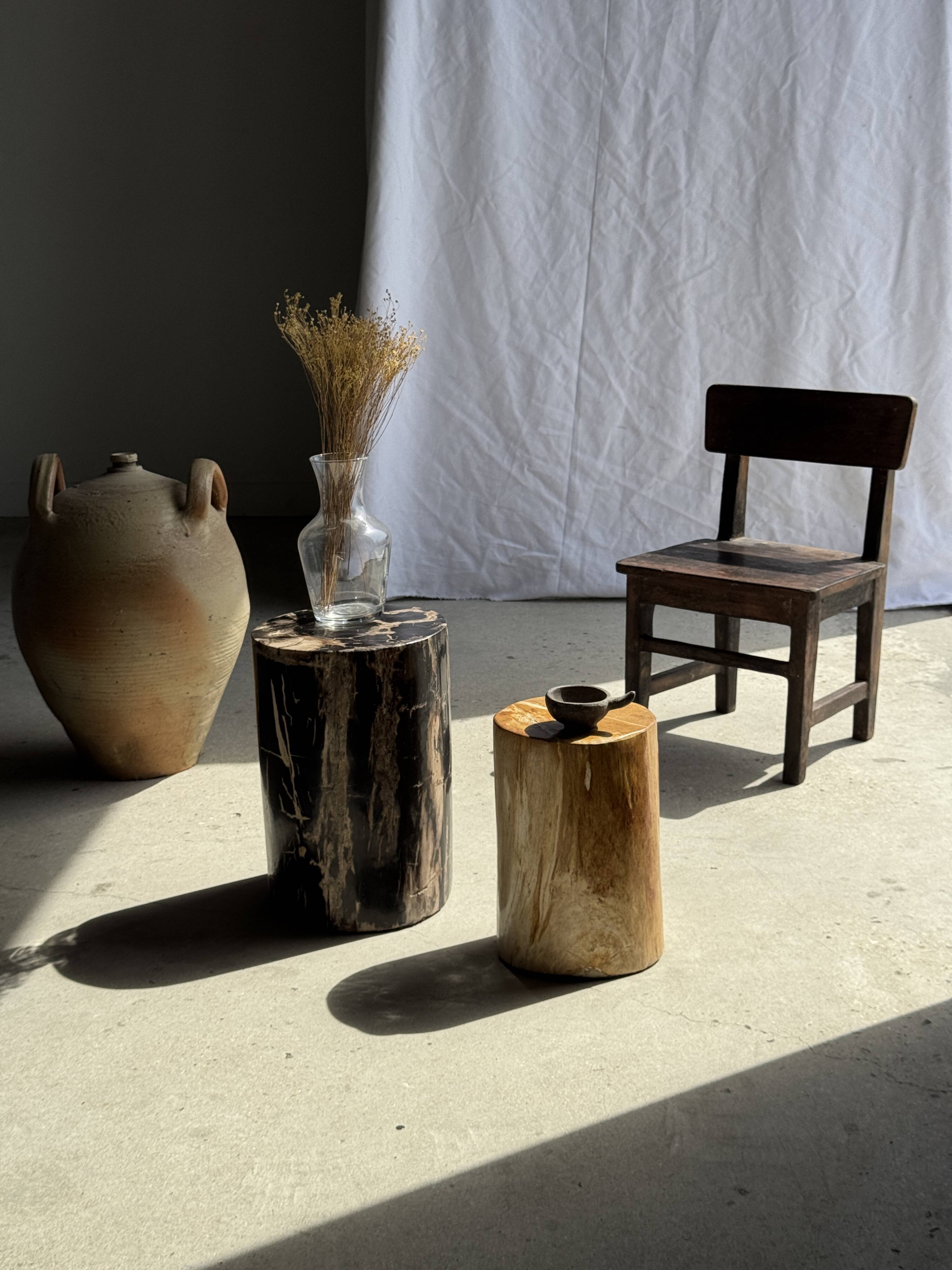 Black petrified wood side table with beige stripes and a semicircular shape.