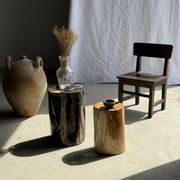 Black petrified wood side table with beige stripes and a semicircular shape.
