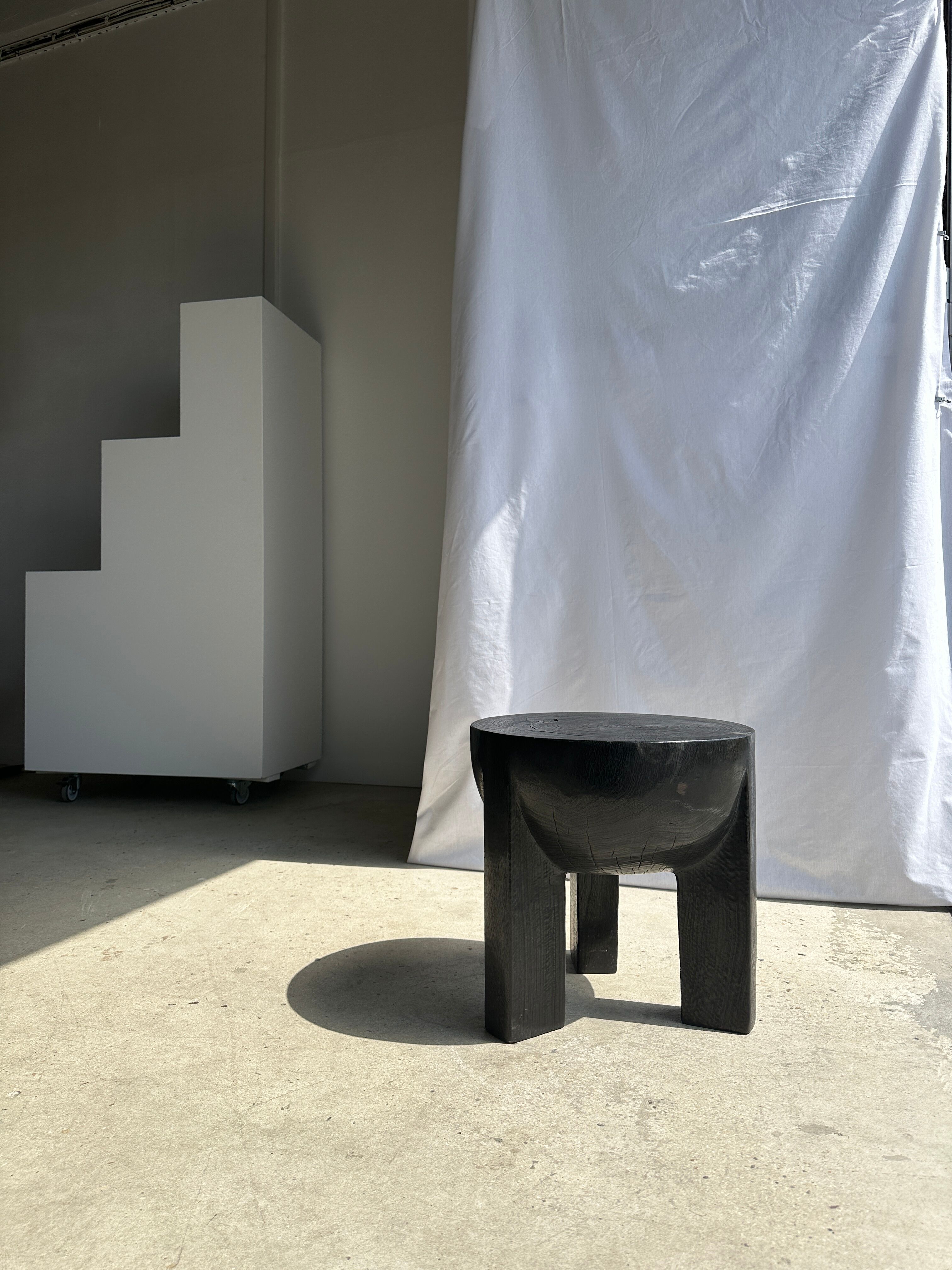 Black mango wood tripod side table with a semi-spherical top, height: 45 cm, diameter: 44 cm.