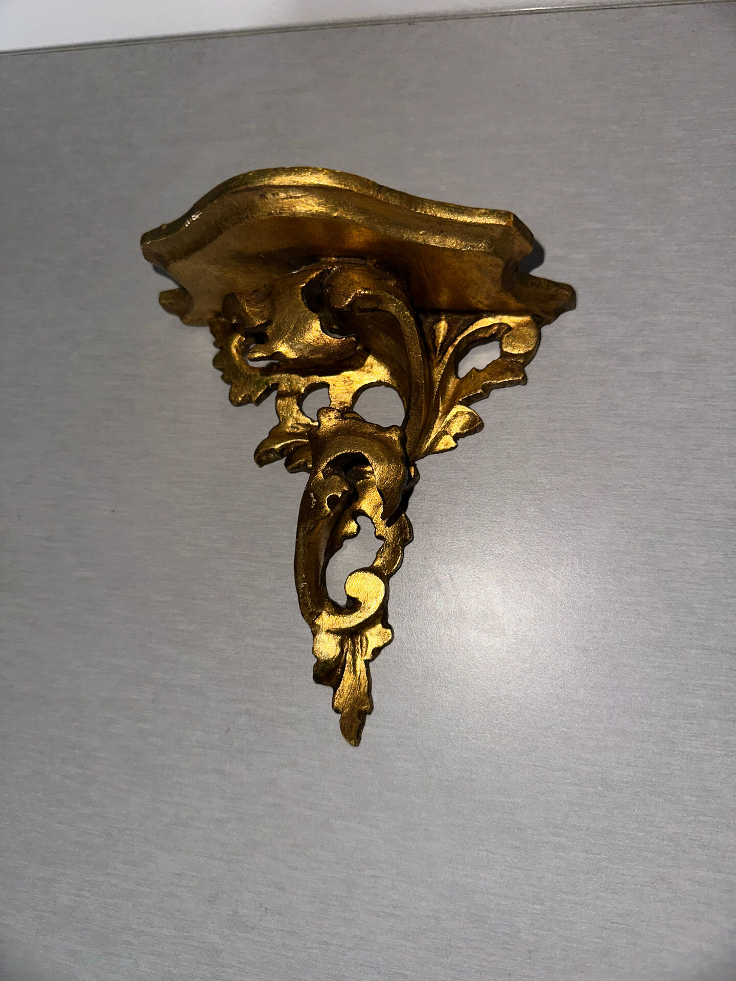 Antique wall-mounted console in gilded wood in rococo style.