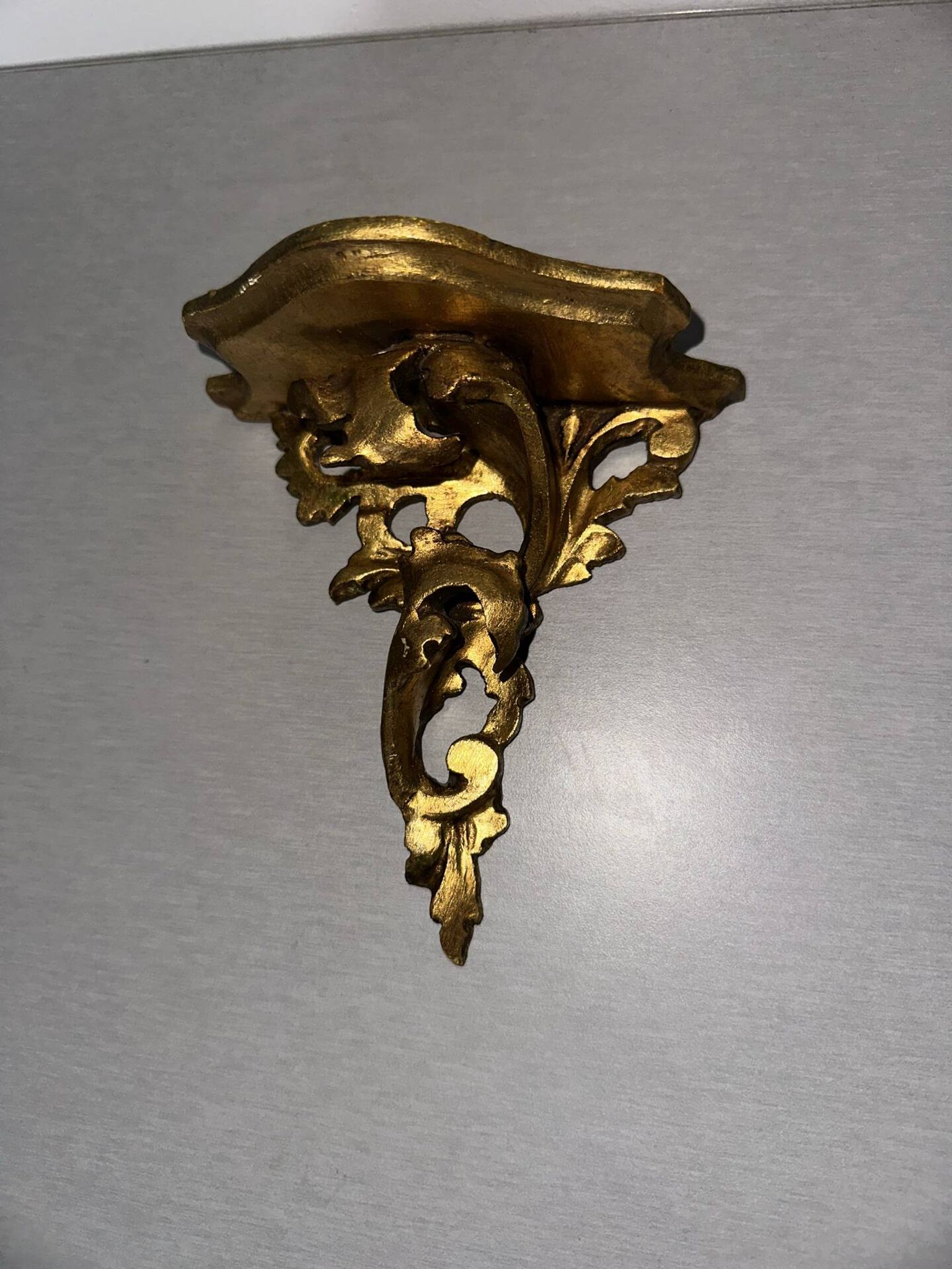 Antique wall-mounted console in gilded wood in rococo style.