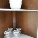 Vintage English corner display cabinet enhanced in grey-green with a wooden top.