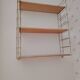 Vintage modular wall shelf in golden steel wire and wood from the 1950s.
