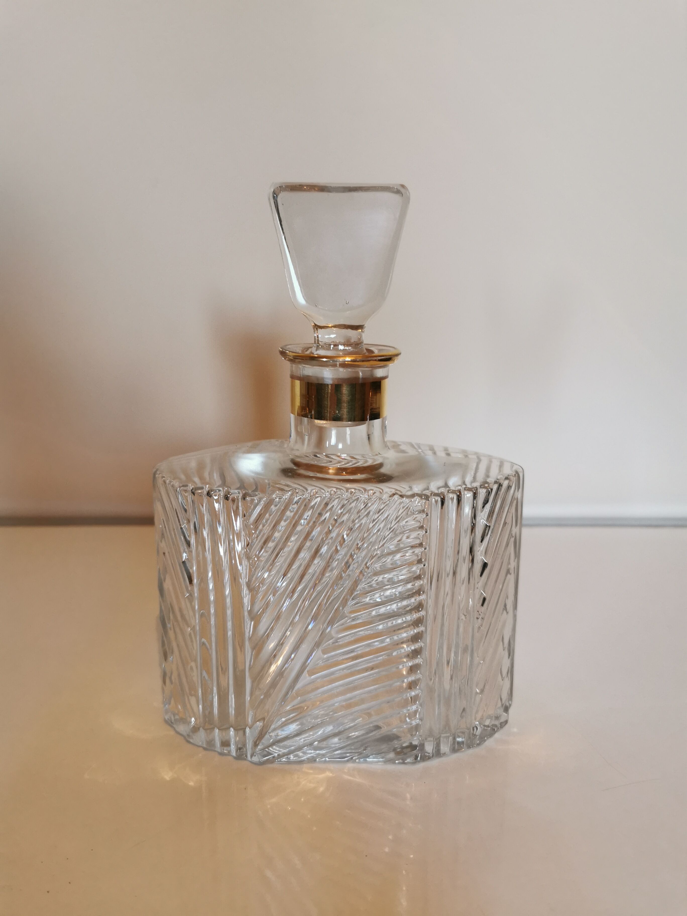 Carved glass decanter, golden band on the collar