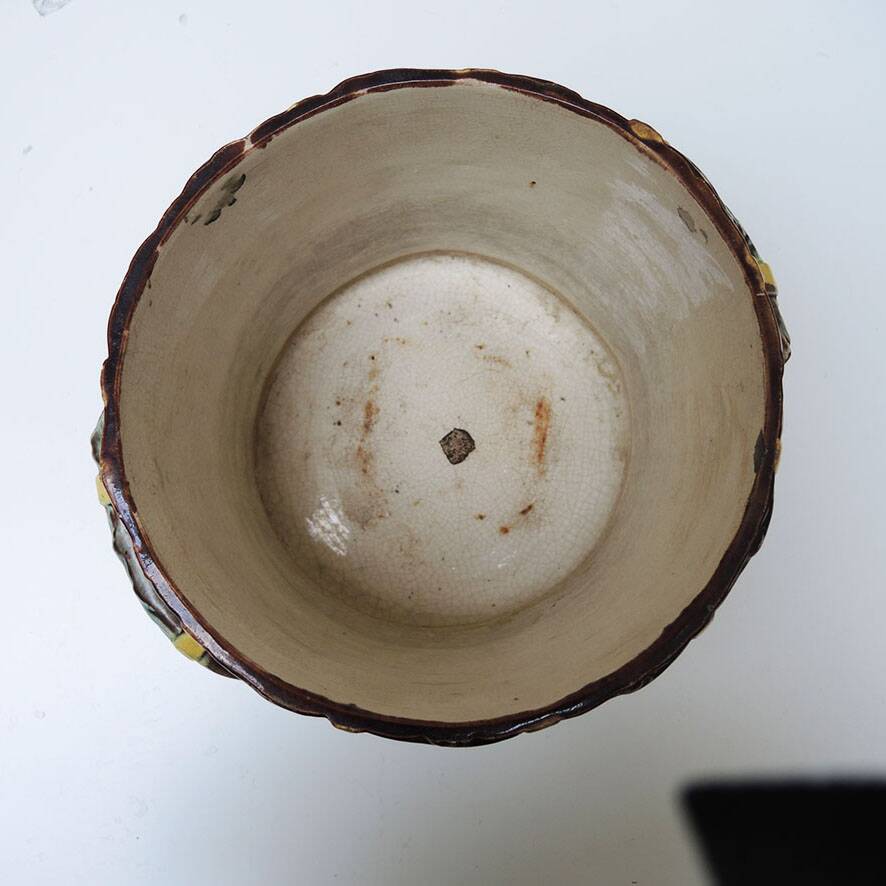 Old earthenware pot with ivy decoration.