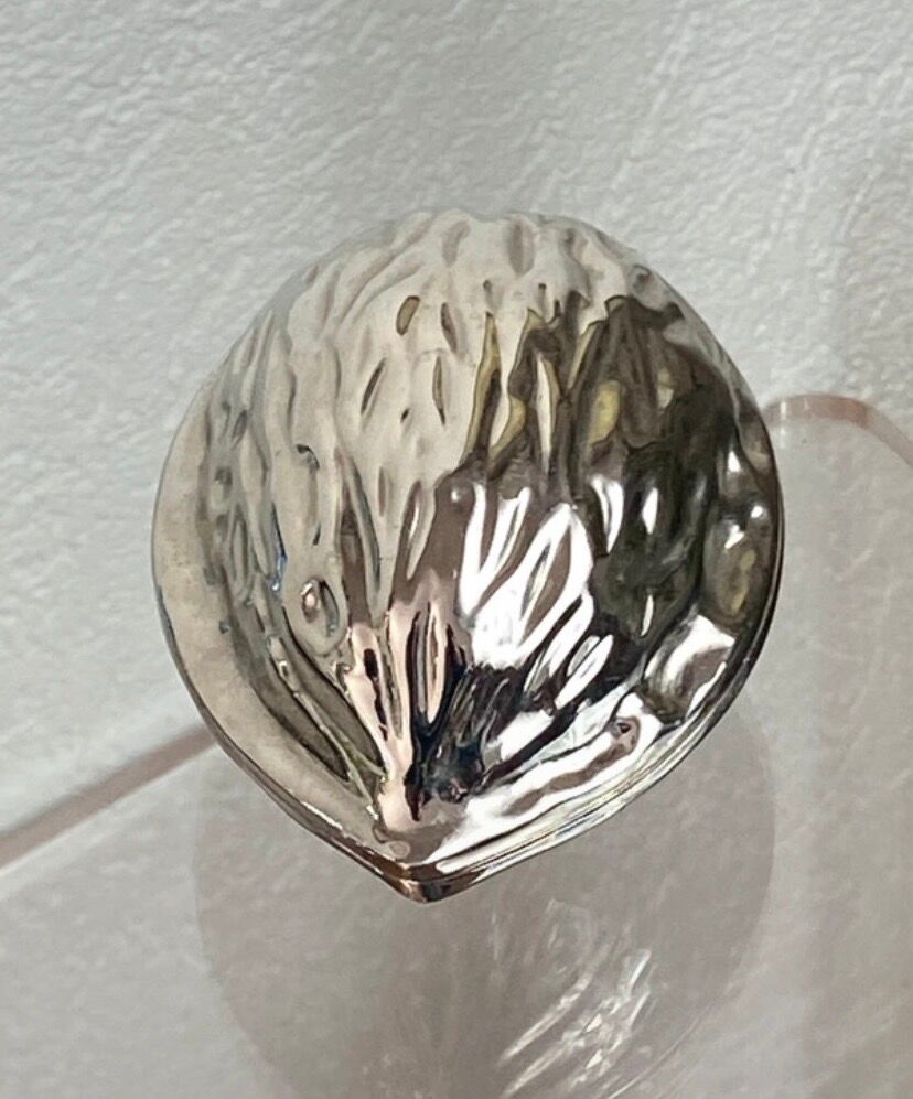 Nutcracker in the shape of a nut in silver-plated metal.