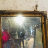 Old mirror with gilded leaves and flowers carved on top of it 1800s