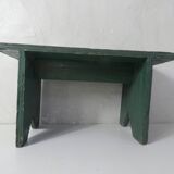 Old small wooden bench with green foot