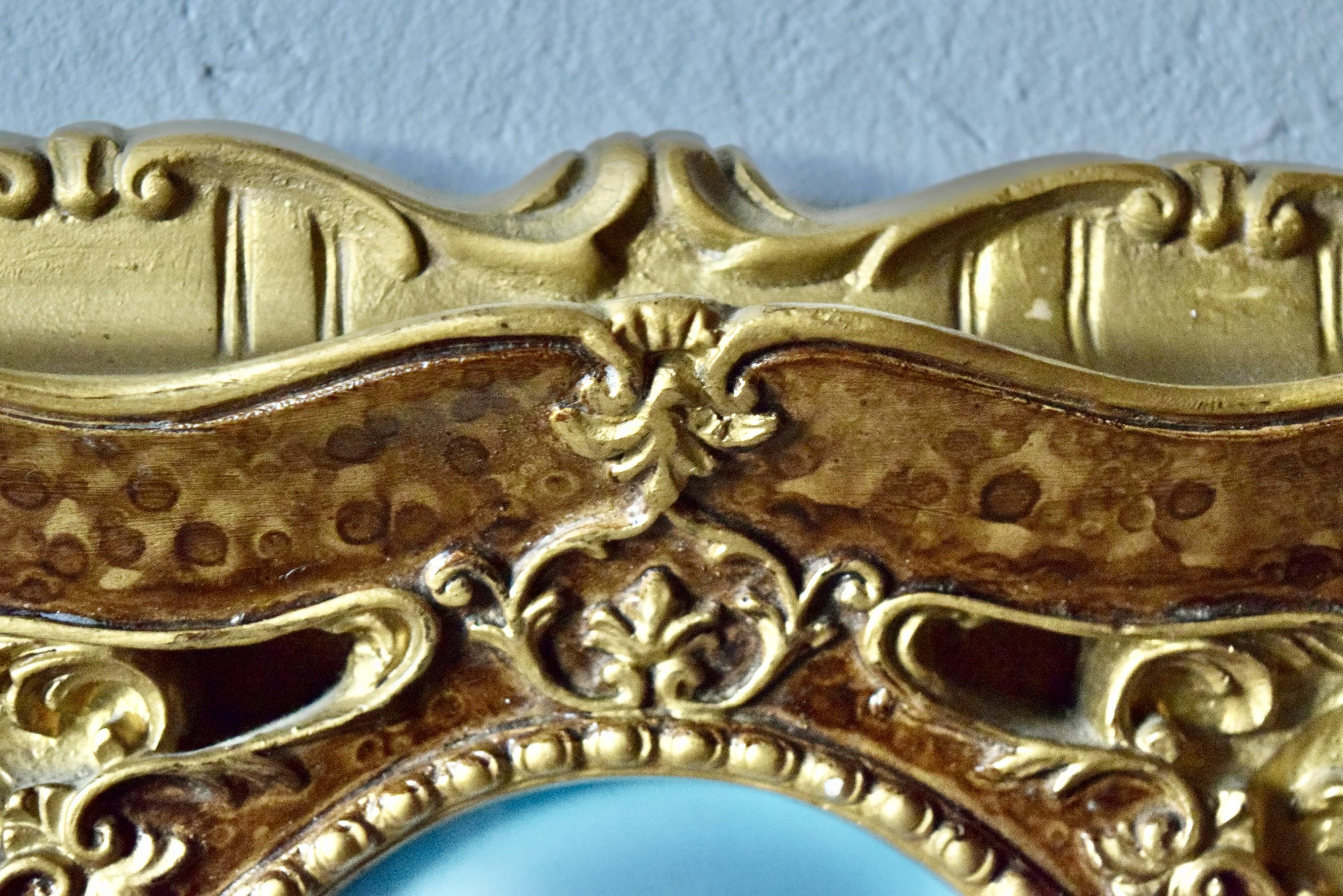 Old religious light frame in gilded stucco and curved glass