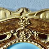 Old religious light frame in gilded stucco and curved glass