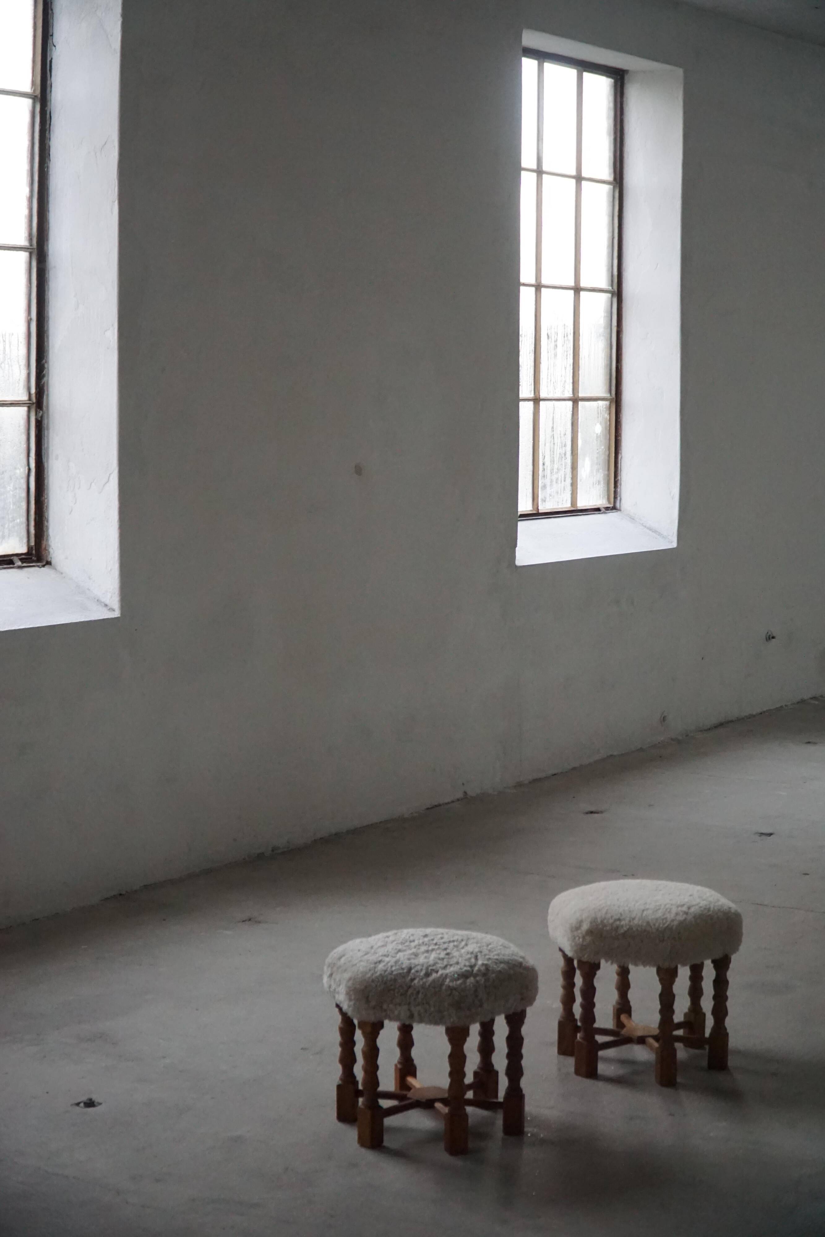 Pair of mid-century Danish oak stools with shearling lambswool upholstery, 1950s.