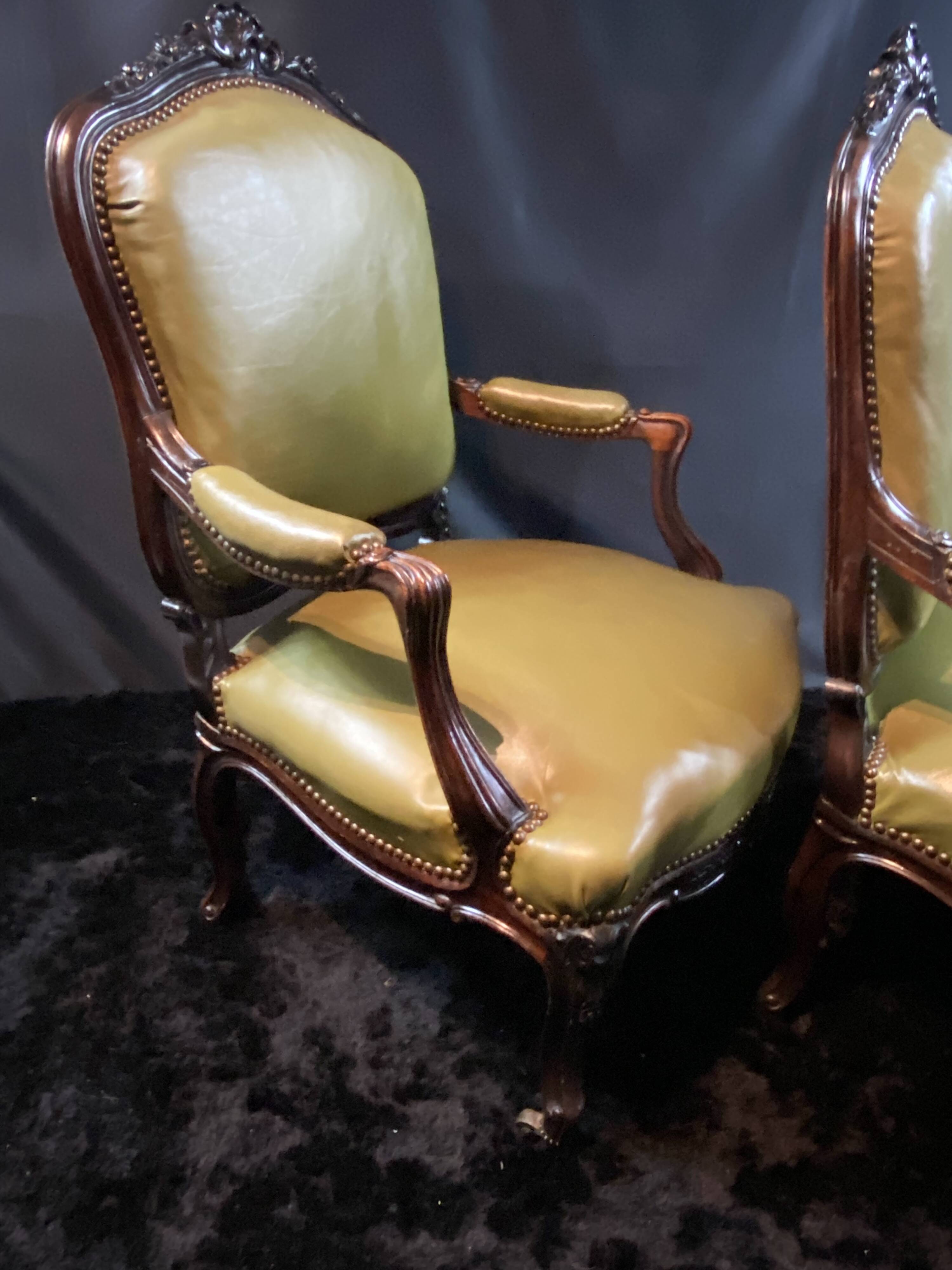 Paire de larges fauteuils XIXe en cuir vert de style Louis XV