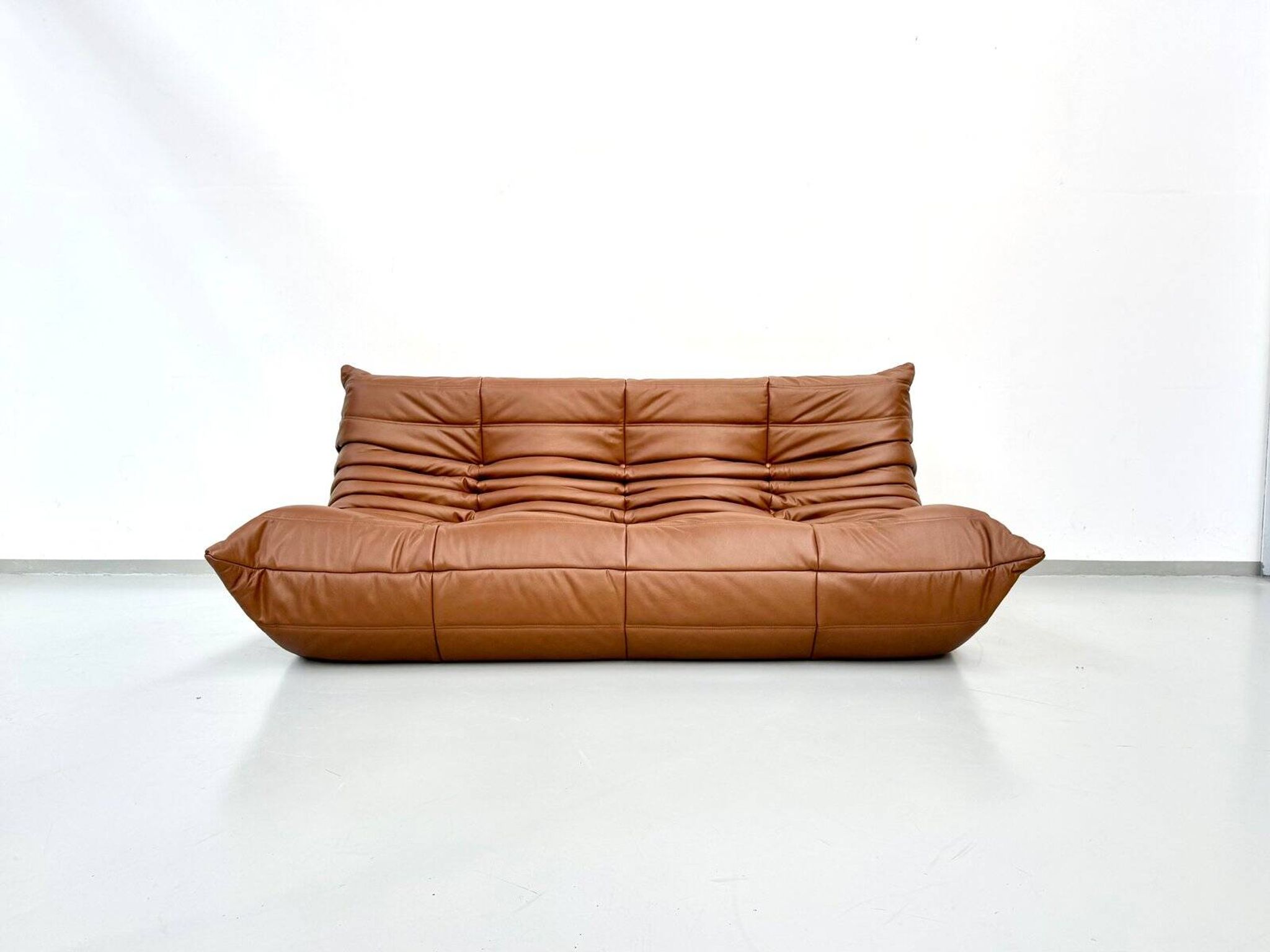 Three-seater Togo sofa in dark cognac leather by Michel Ducaroy for Ligne Roset.