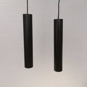 Two cylinder-shaped hanging lamps in black lacquer