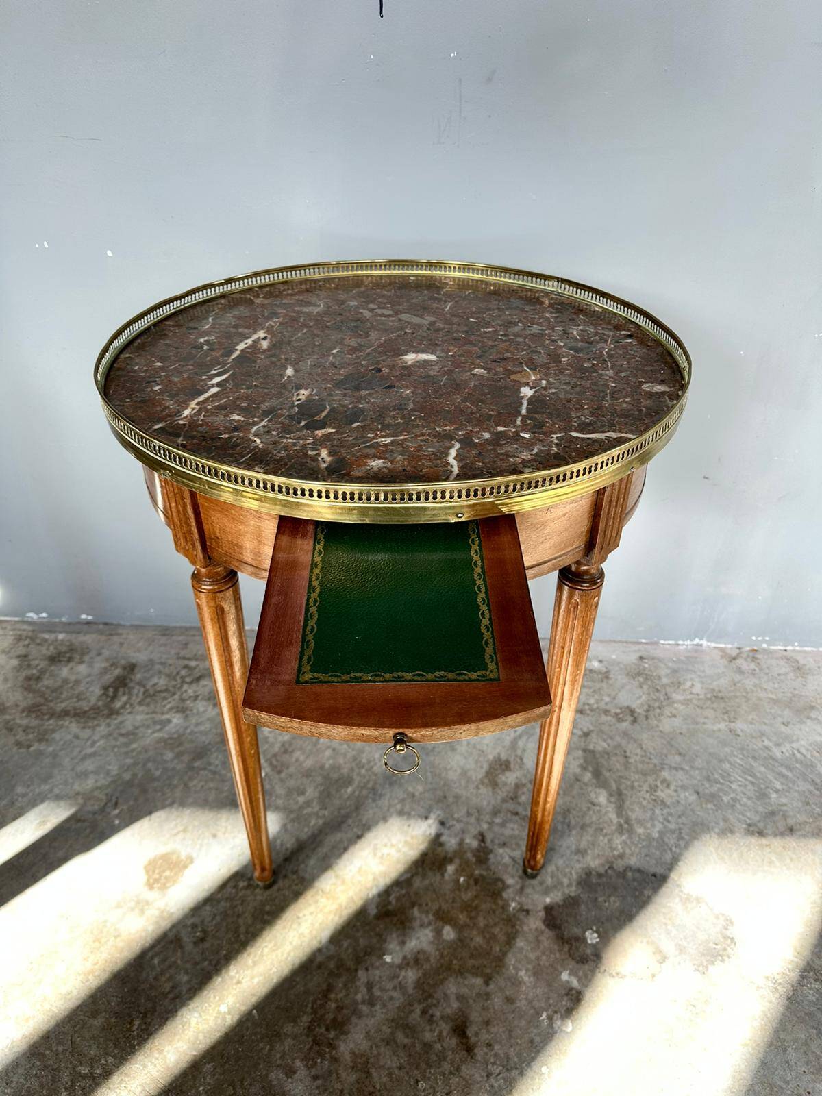 Hot water bottle table with a marble top and a brass gallery.