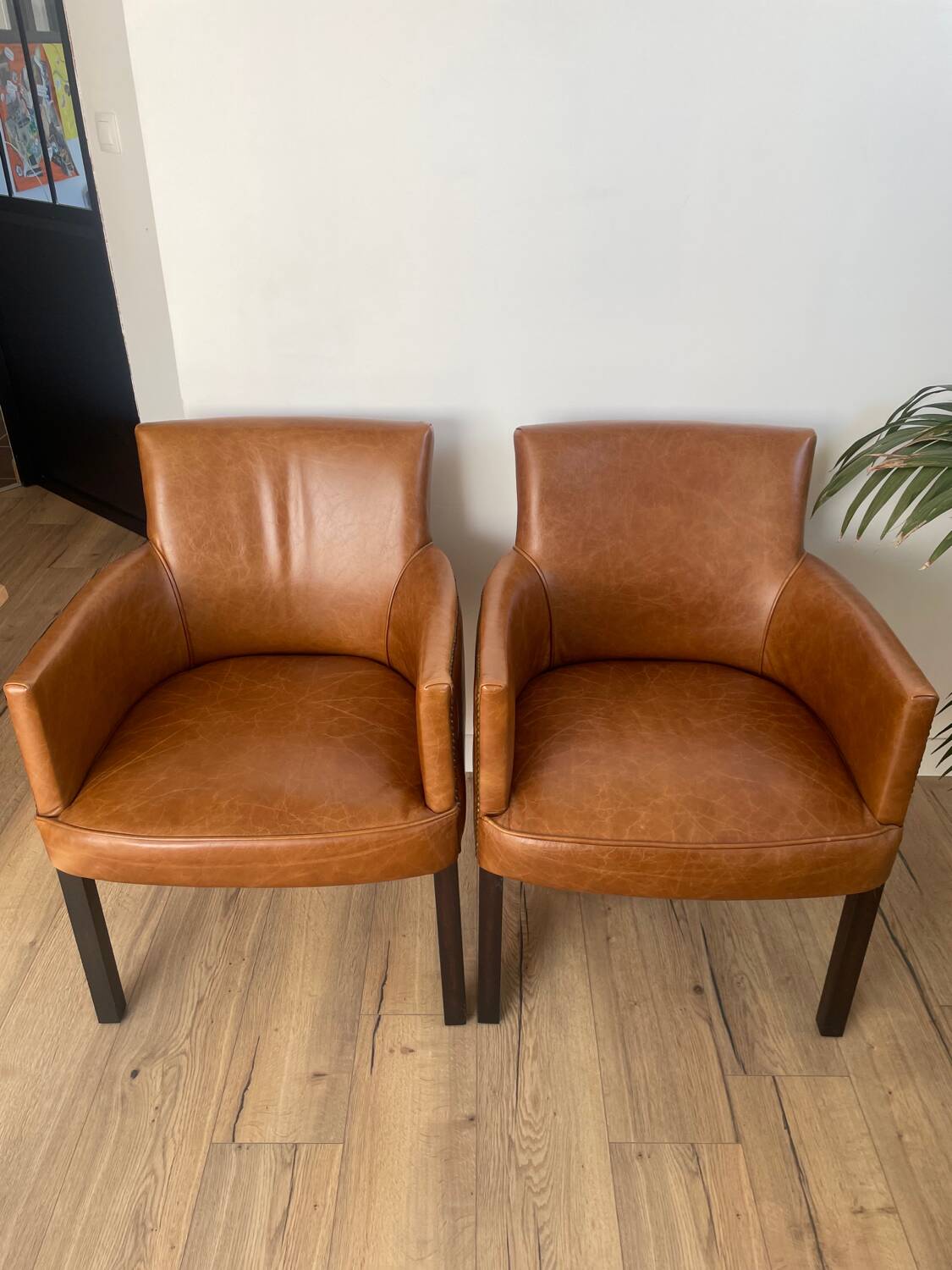 Chair with armrests in aged brown cowhide leather