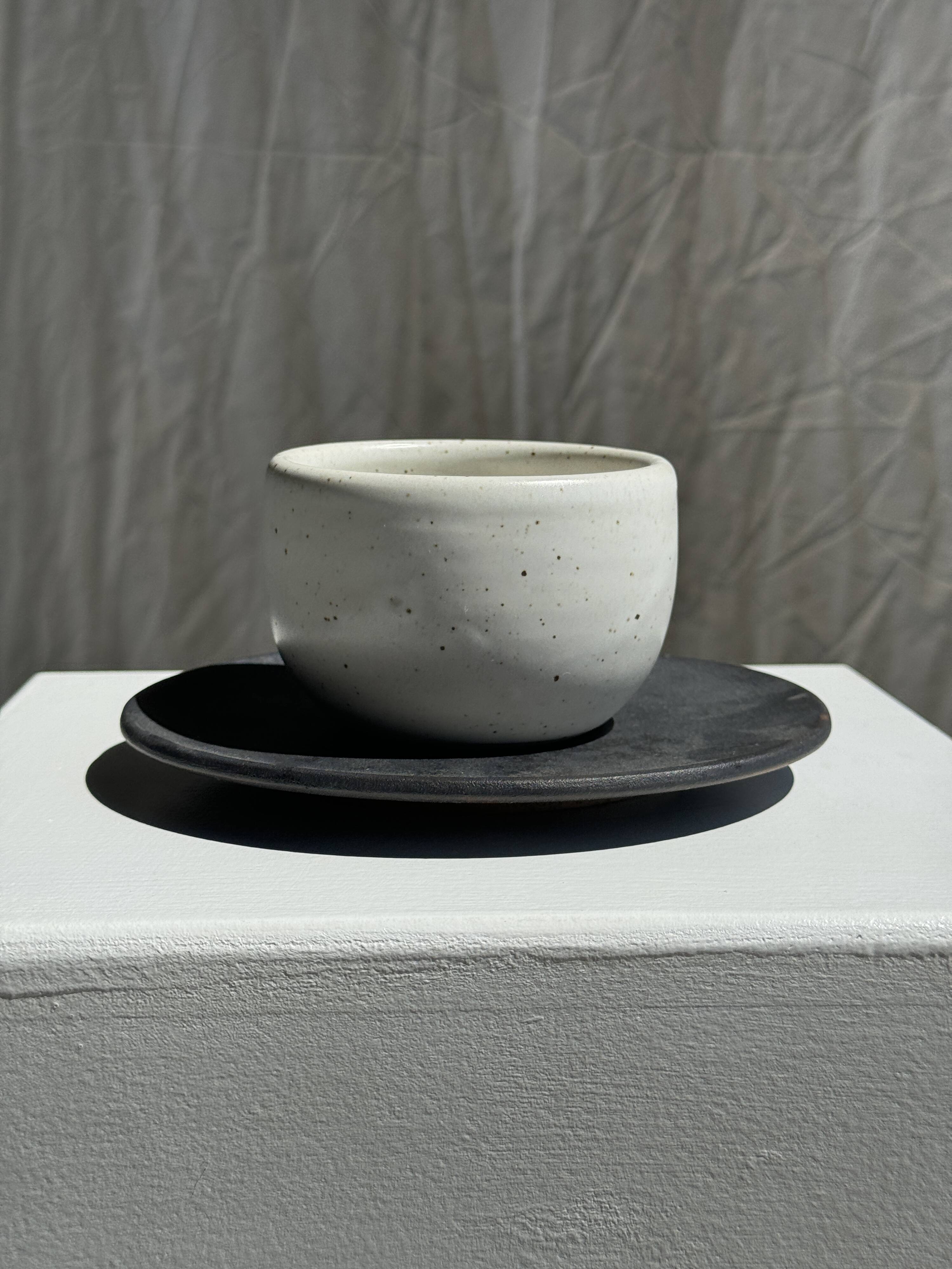 White Indonesian ceramic cup and gray saucer
