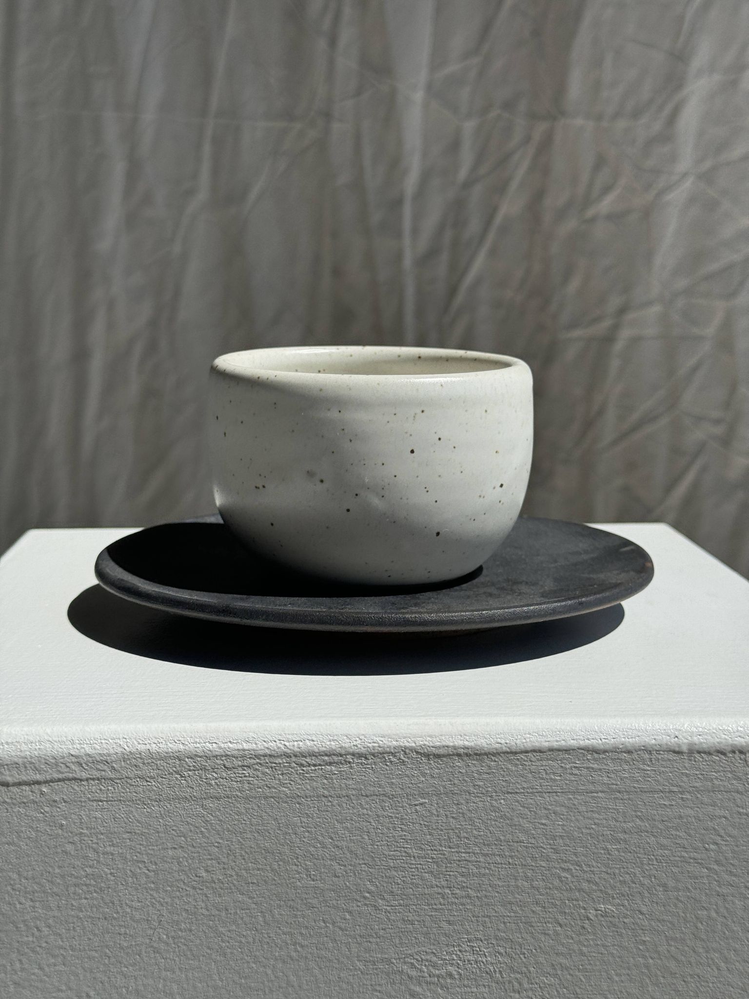 Tasse blanche en céramique indonésienne et soucoupe grise