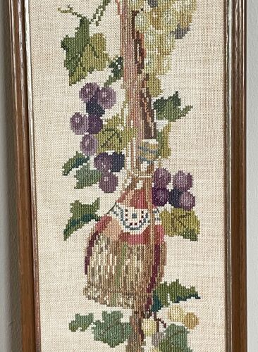 Broderie hollandaise encadrée représentant la vigne avec des raisins, des bouteilles de vin et des paniers
