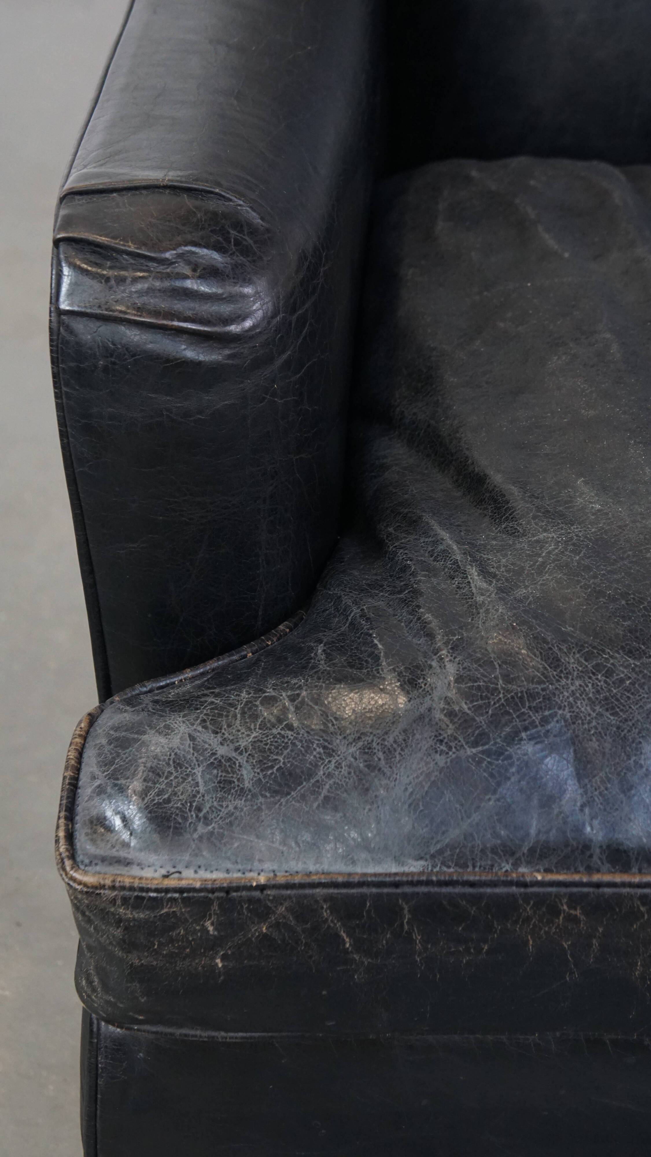 Armchair in black grained cowhide leather with a deep seat