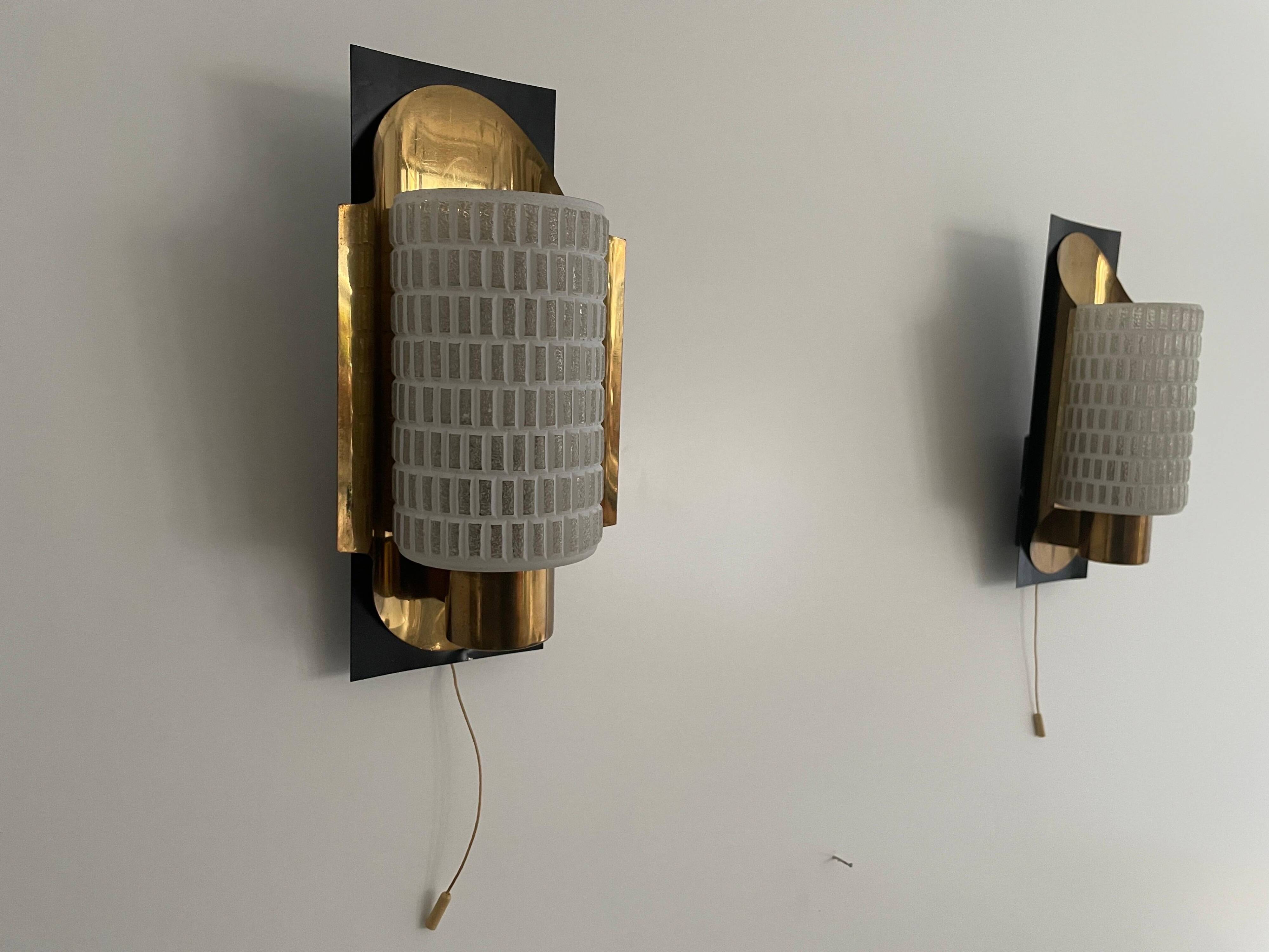 Mid-century pair of wall sconces in textured glass and brass, 1950s, Germany.